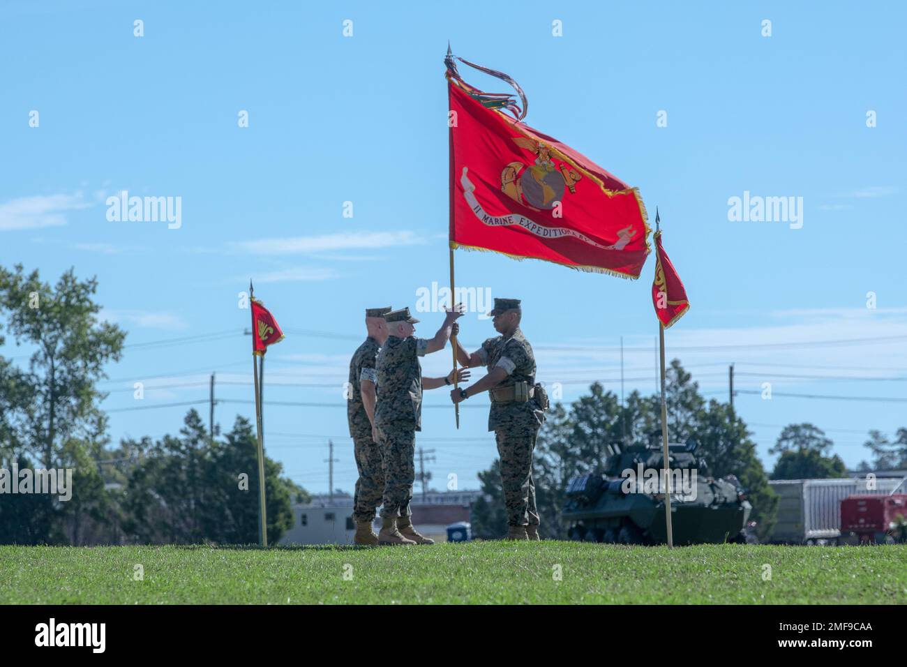 Sgt. Maj. Lonnie N. Travis Jr. (right), the sergeant major of II Marine  Expeditionary Force (MEF), passes the colors to Lt. Gen. William Jurney  (center), relinquished commanding general of II MEF, during