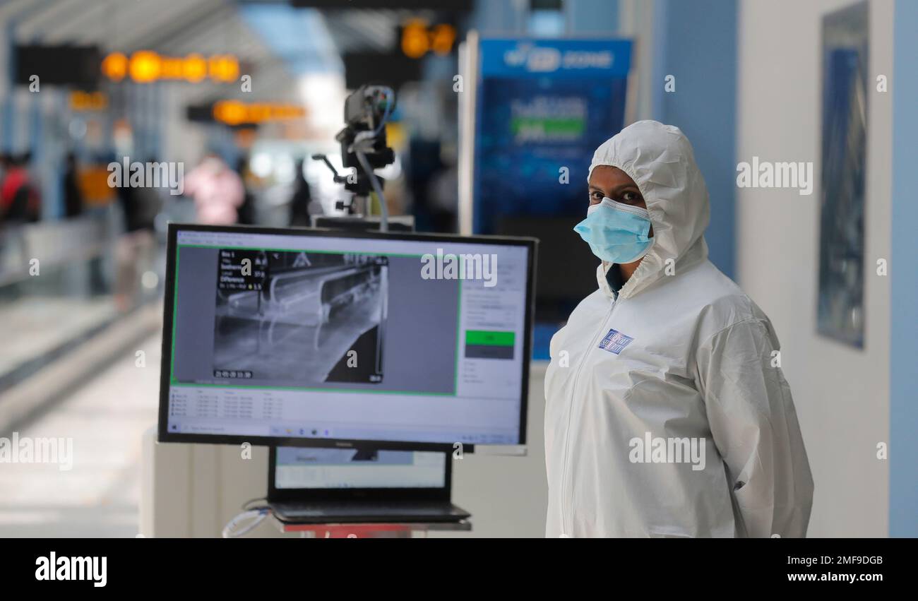 A Sri Lankan airport worker stands next to a thermal scanner inside a
