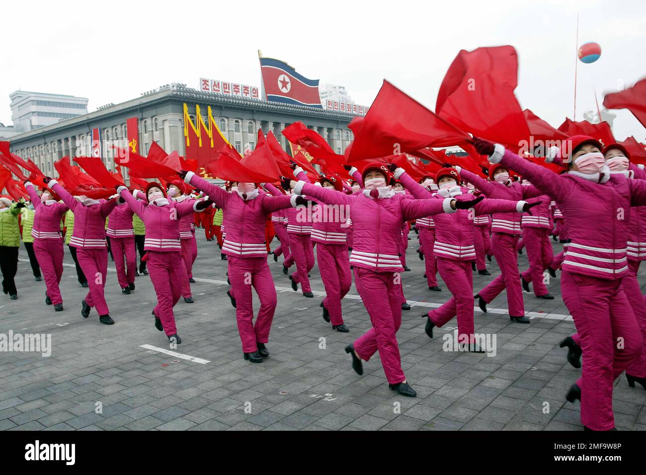 Waving red flags during a mass rally the Pyongyang city army-people ...