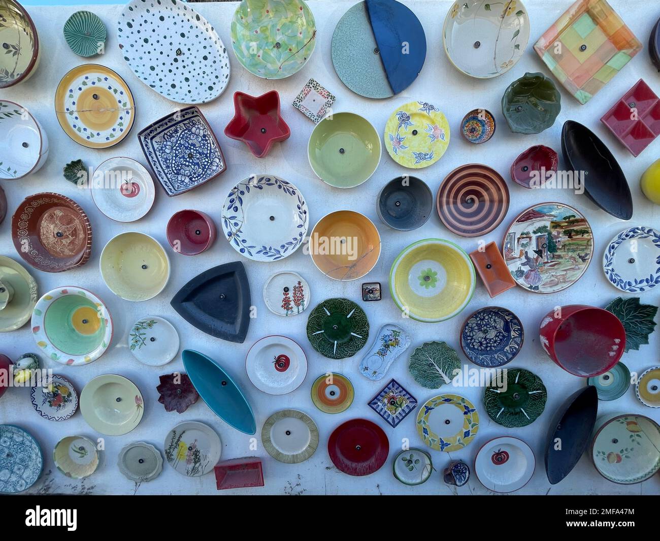 A top view of colorful ceramic plates and bowls with unique patterns on