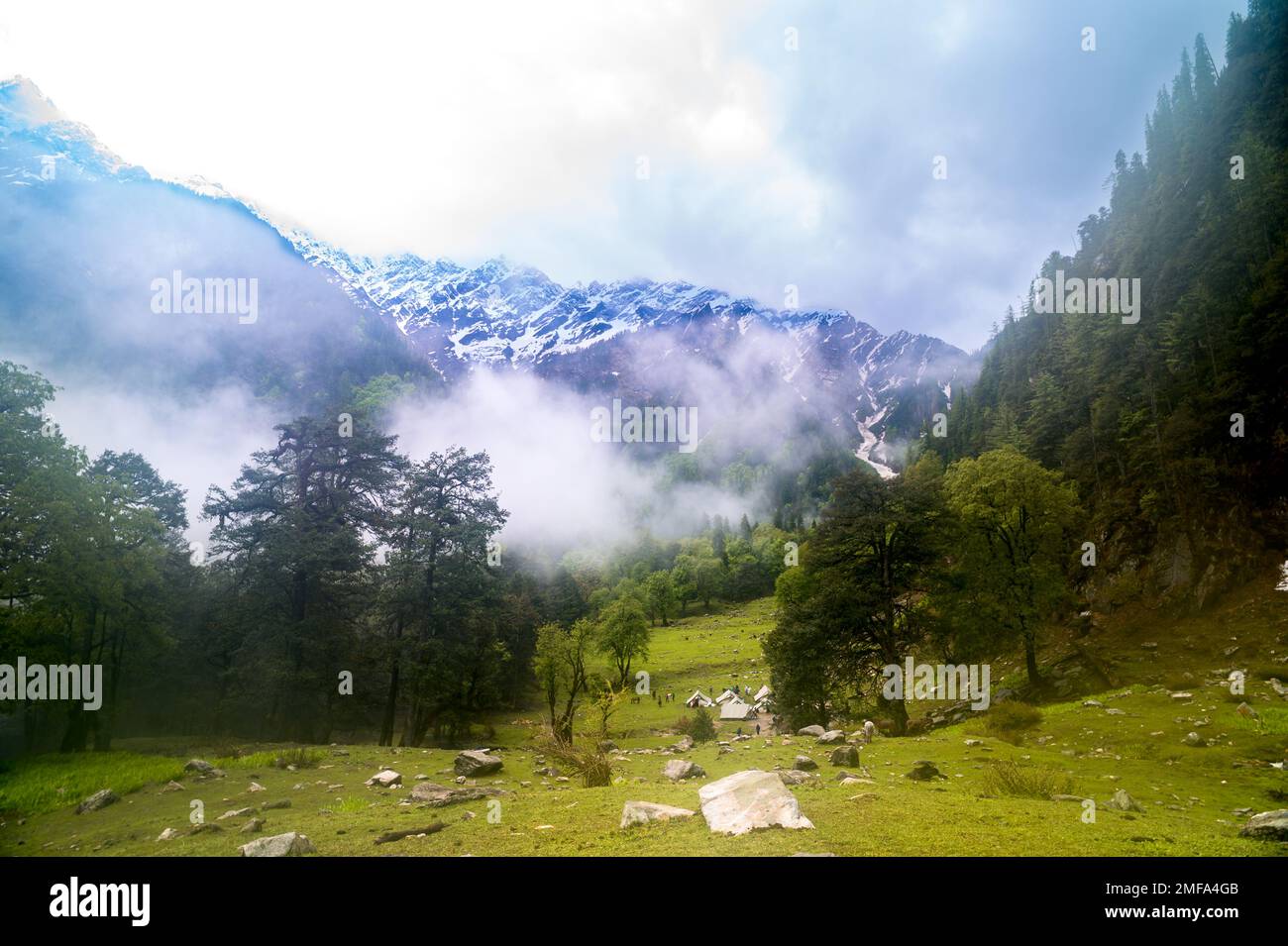 Landscape with fog. This is the scenic view of the Himalayas peaks and alpine landscape from the trail of Sar Pass trek Himalayan region of Kasol, Him Stock Photo