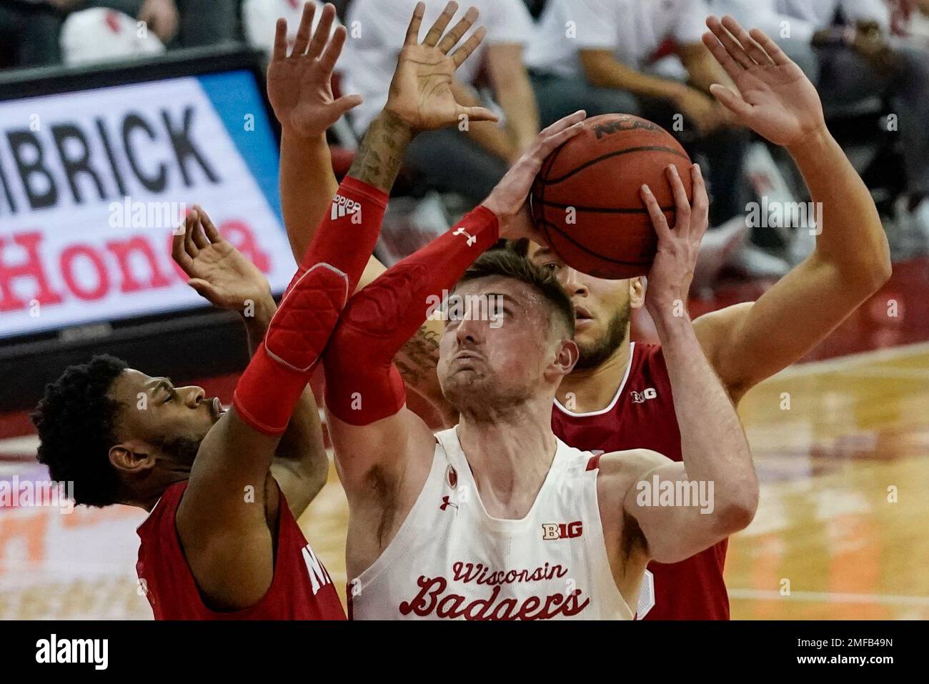 Wisconsin's Micah Potter looks to shoot between Indiana's Al Durham and