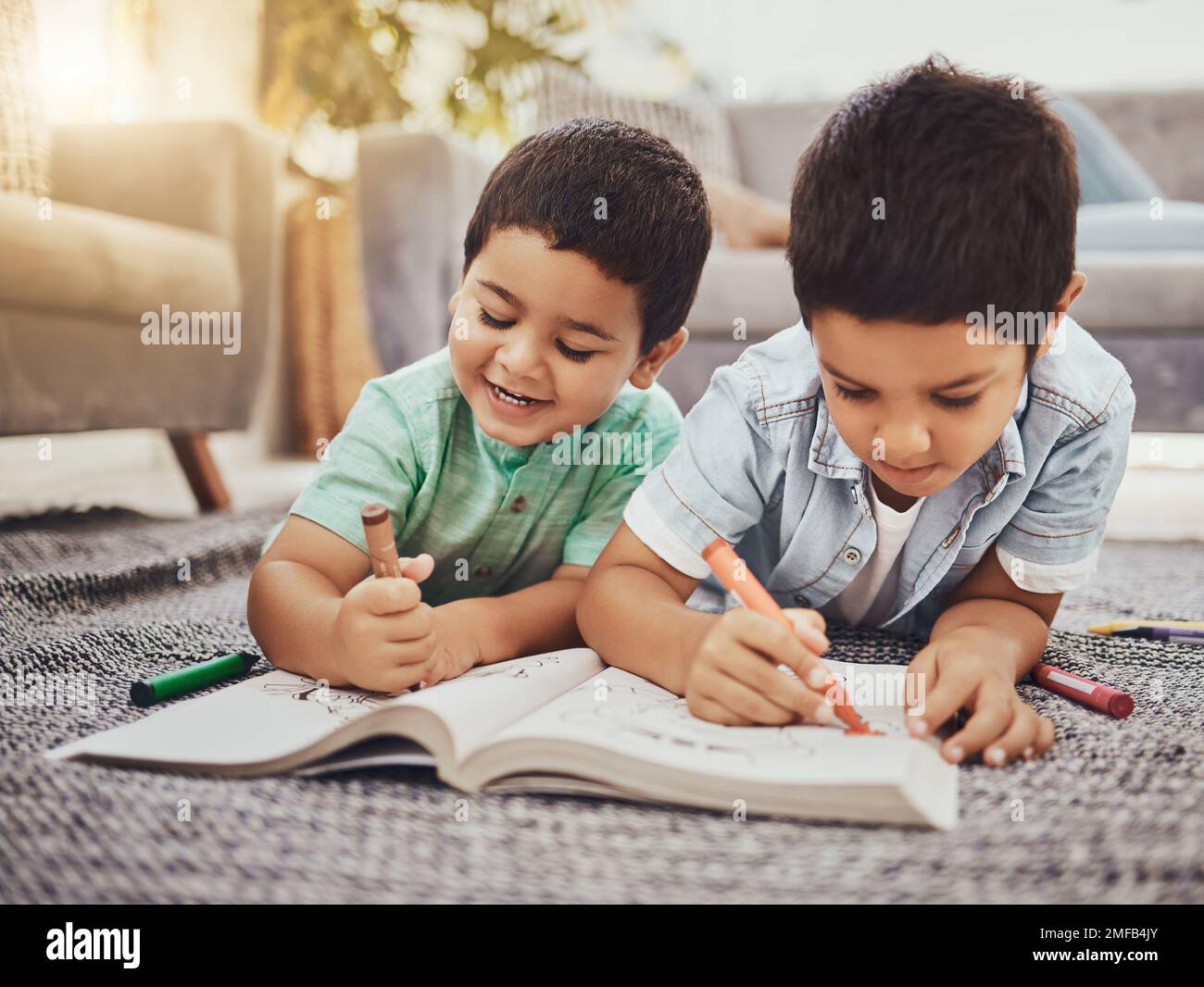 Children, learning and brothers drawing on a floor in their home, relax ...