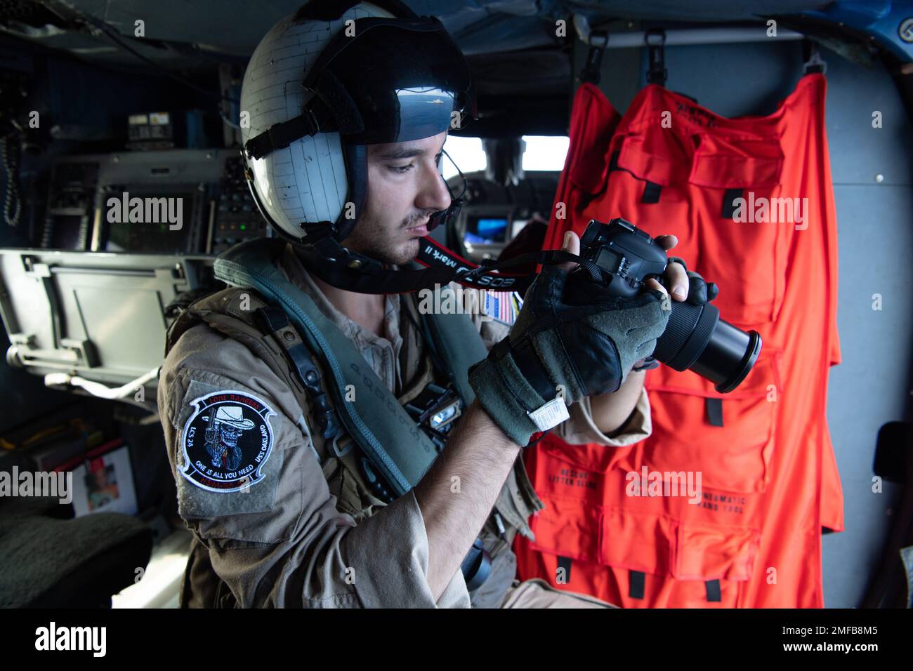 Naval Air Crewman (Helicopter) 2nd Class Michael Fuzie, of Modesto, Calif., supports an airborne reconnaissance mission from the back of an MH-60R Seahawk helicopter, assigned to Helicopter Maritime Strike squadron (HSM) 35, Aug. 19. 2022. An HSM-35 detachment is embarked aboard Independence-variant littoral combat ship USS Oakland (LCS 24) in support of the Oceania Maritime Support Initiative, a secretary of defense program leveraging Department of Defense assets transiting the region to increase the Coast Guard’s maritime domain awareness, ultimately supporting its maritime law enforcement o Stock Photo