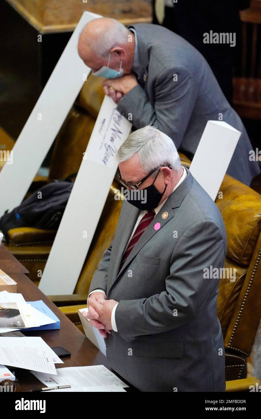 House members bow their heads in prayer on the first day of the 2021