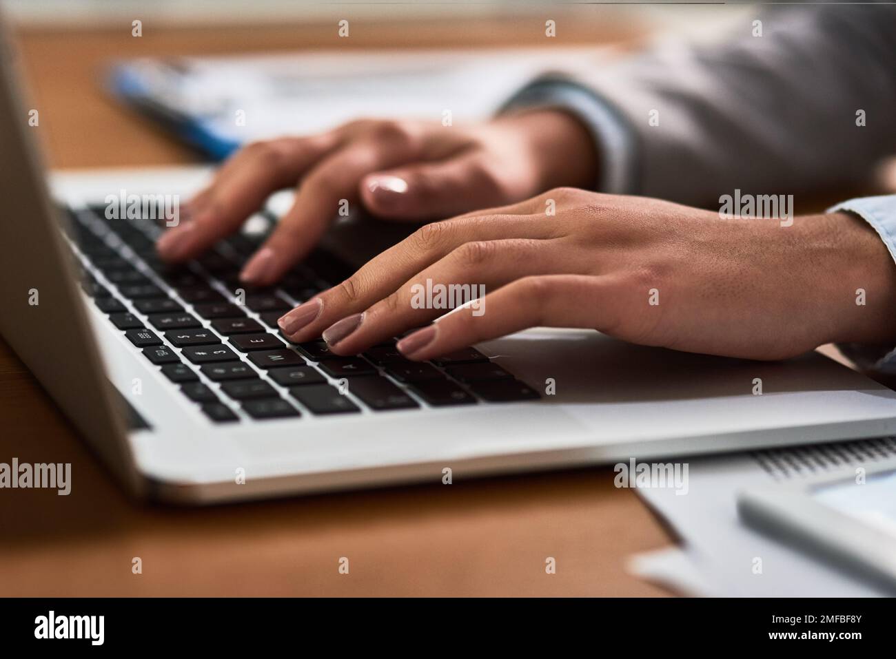 Hardworking hands were made for business. a businesswoman using a laptop at her desk in a modern office. Stock Photo