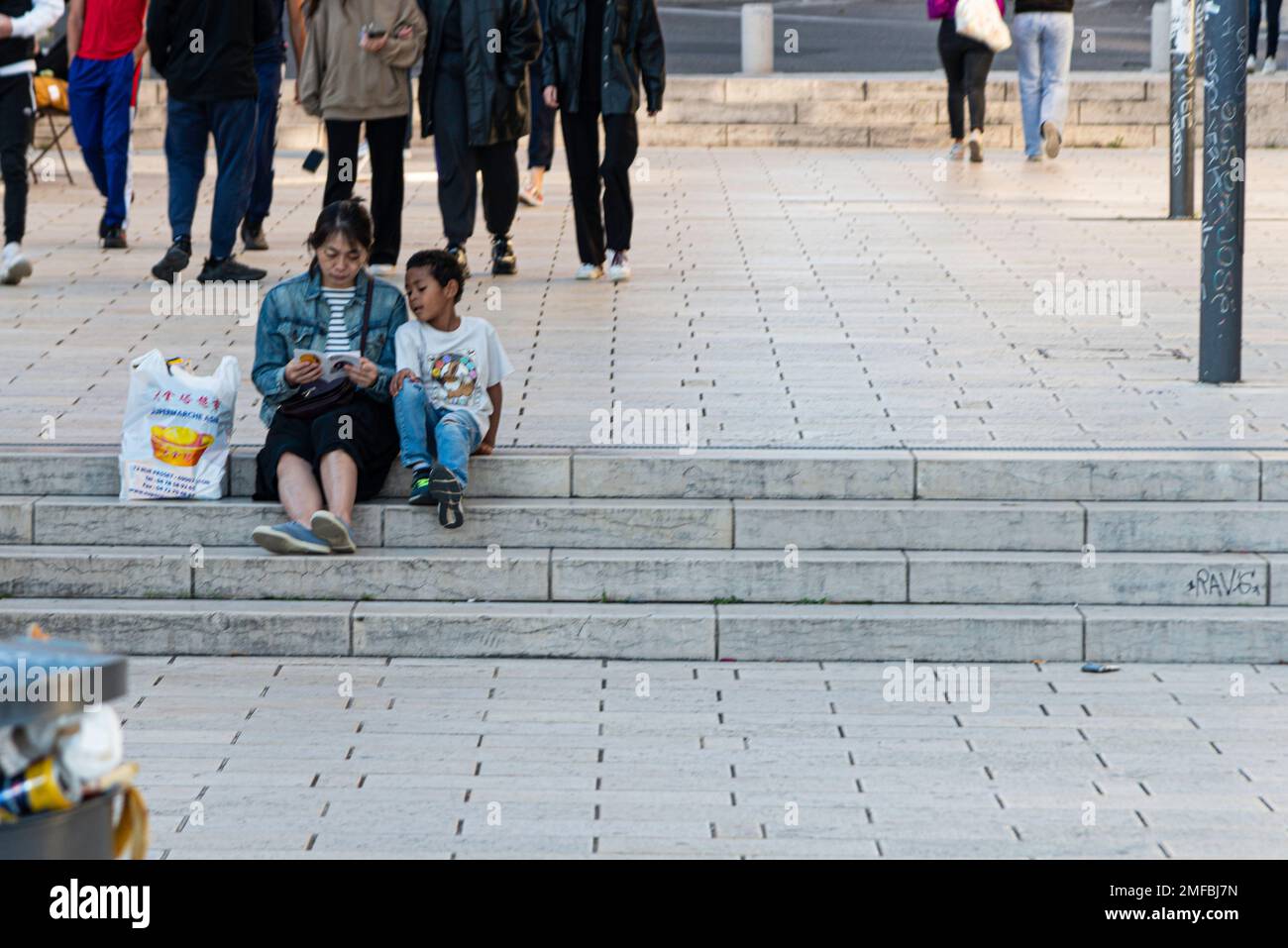 Mother and son sitting on steps outside in Lyon, France Stock Photo