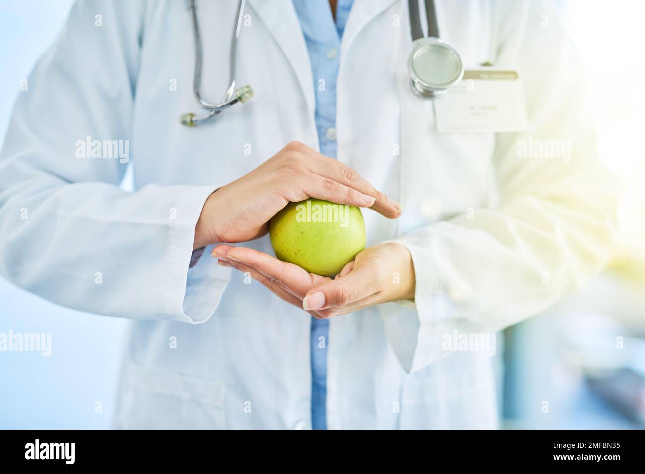 Apples are extremely rich in important antioxidants. Closeup shot of an unidentifiable doctor holding an apple in her hands. Stock Photo