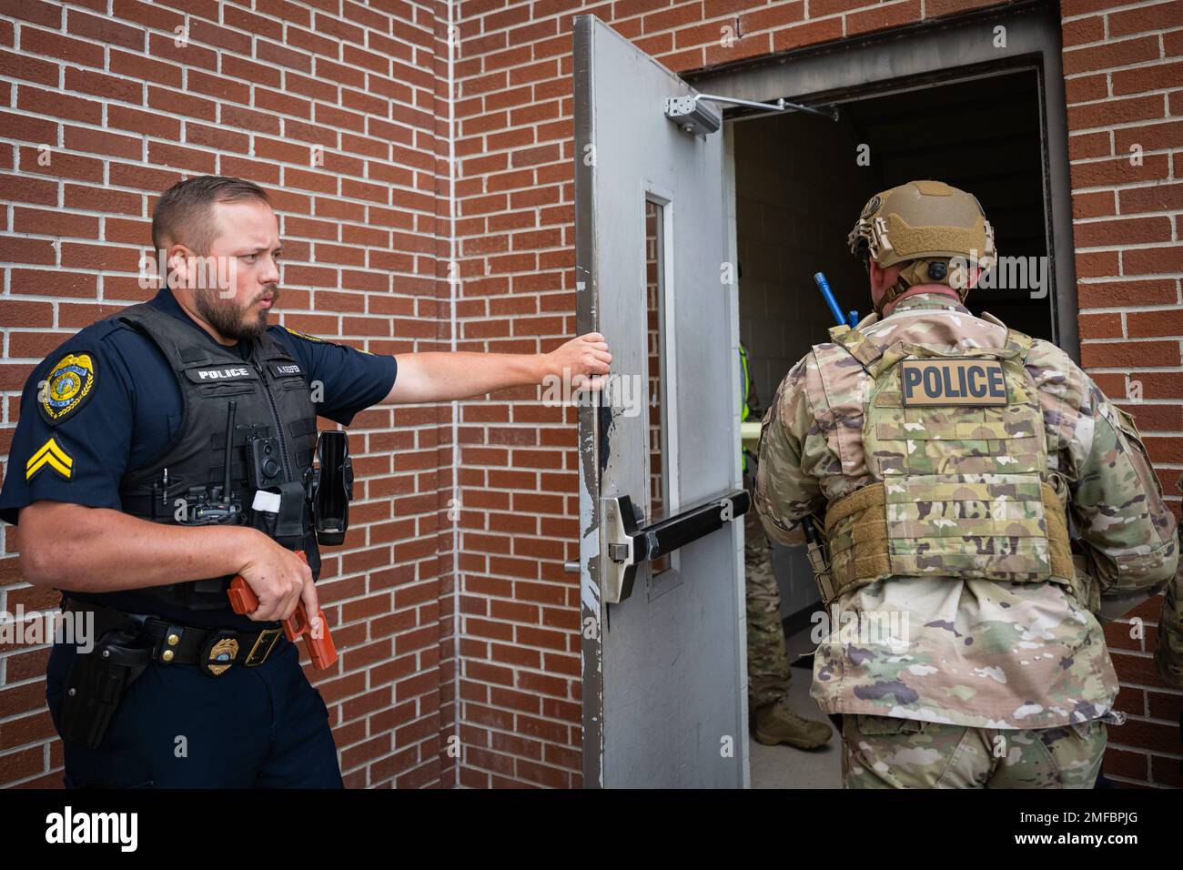 A member of the Goldsboro Police Department holds a door for an Airman
