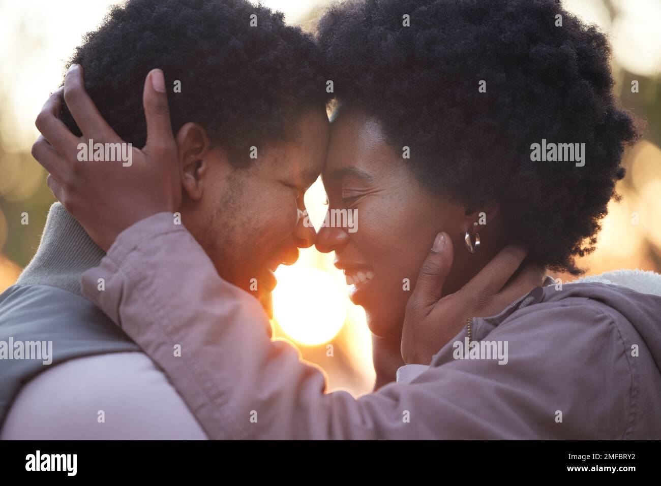 Couple, love and hiking in sunset kissing and faces touching outdoors after workout, fitness and exercise. Romantic African American healthy people Stock Photo
