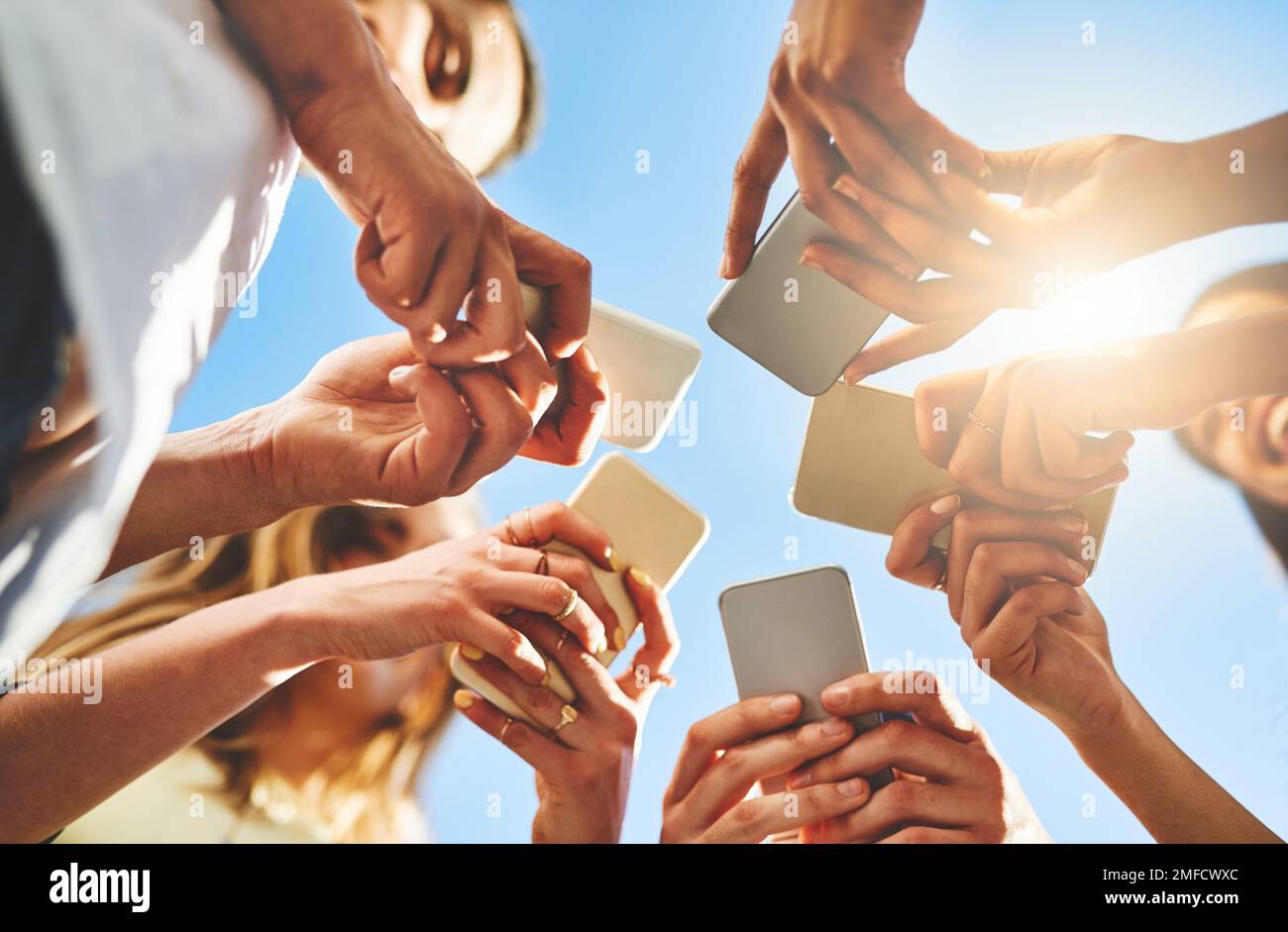 Getting connected today is very easy. unrecognizable people using smartphones outside. Stock Photo