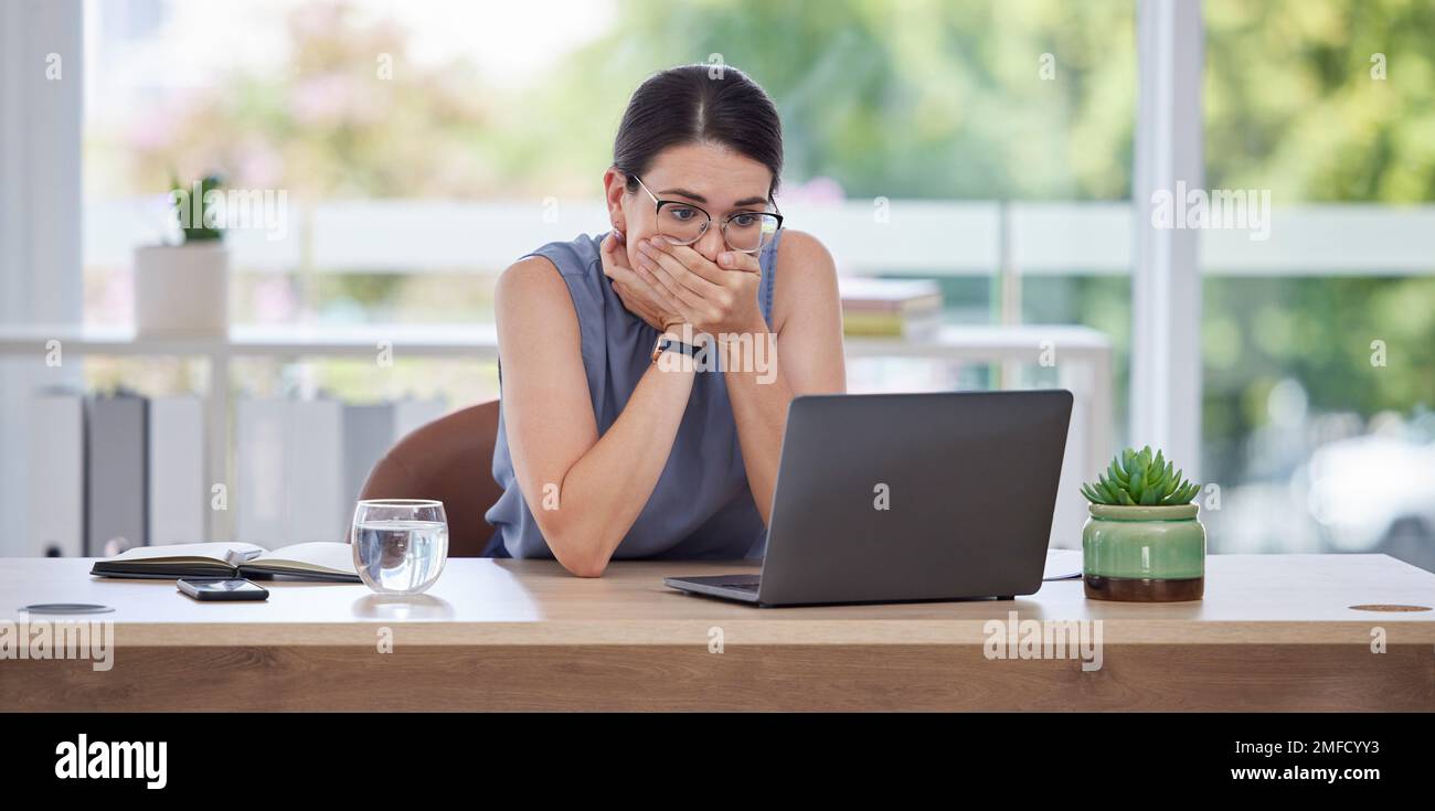 Surprise, mistake or error with a business woman looking shocked while working on a laptop in her office. Computer, glitch and problem with a scared Stock Photo