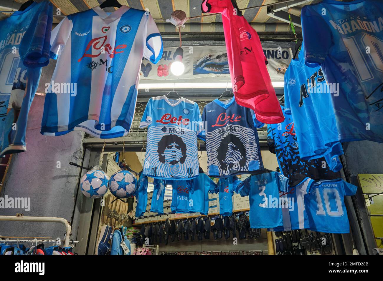 A sporting goods store sells jersesys, uniforms, shirts, tops of famous soccer, football star, Diego Maradona. In Naples, Napoli, Italy, Italia. Stock Photo