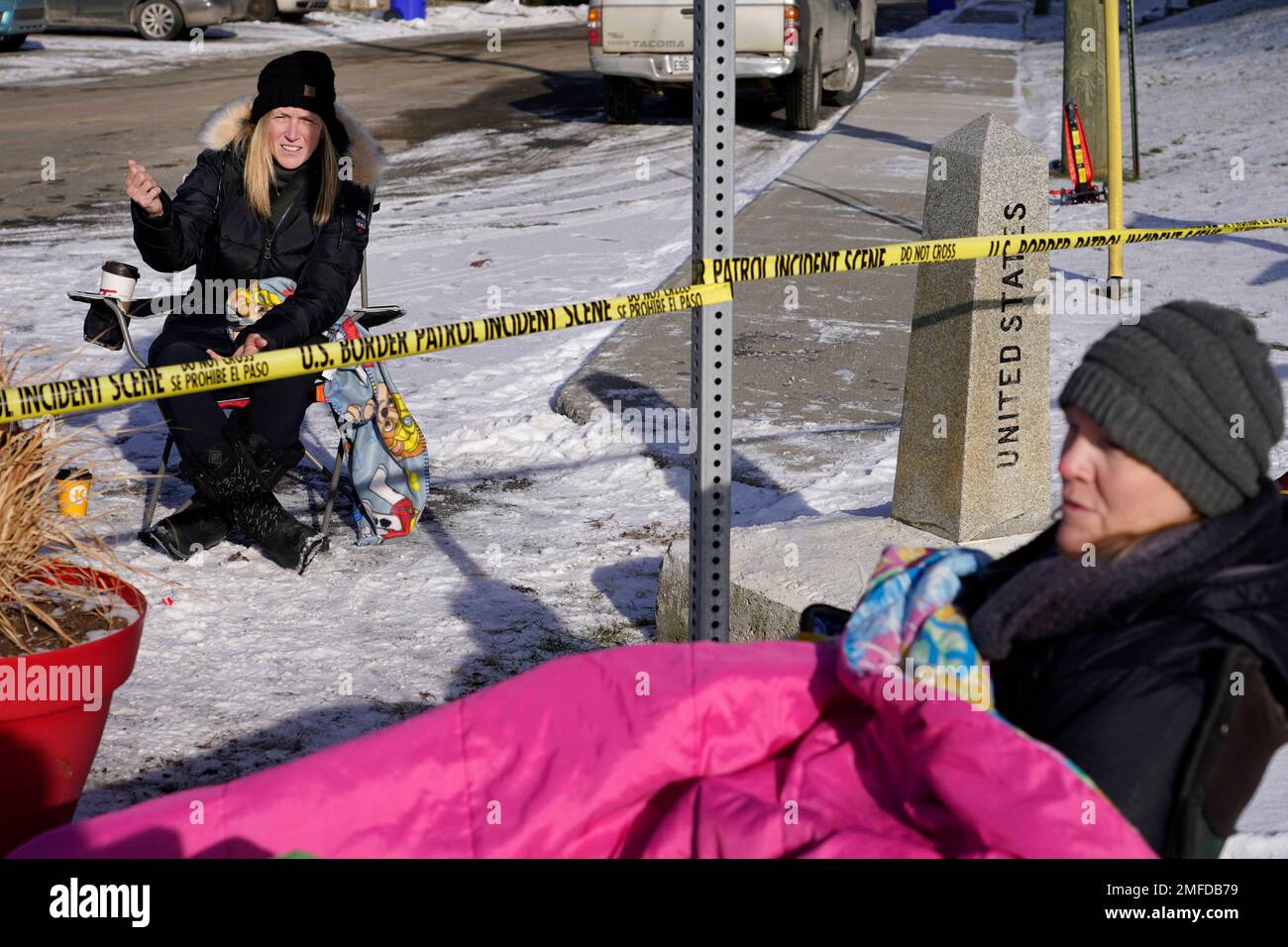 Sisters Stephanie Frizzell, left, of Magog, Quebec, Canada and Sherie Frizzell, right, of Newport Center, Vt., chat as they sit in lawn chairs for a visit, Saturday, Dec. 19, 2020, at the U.S.-Canadian border of Stanstead, Quebec and Derby Line, Vt. The holidays have always been a time when people come together, something that's been true even along international borders where family, friends and communities have long overcome barriers to share in their celebrations. This year they faced their greatest barrier yet _ a global pandemic. (AP Photo/Elise Amendola) Stock Photo