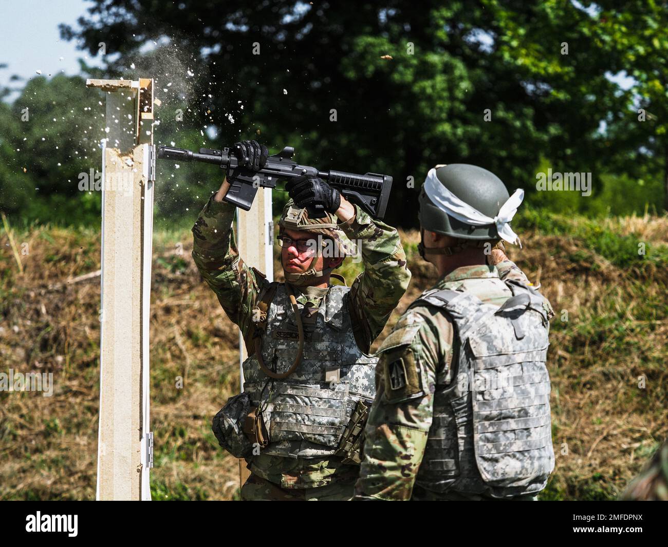 Indiana National Guard Pfc. Felix Sereicikas, a combat engineer with 776th Engineer Battalion, fires a 12-gauge breacher round into a door while practicing breaching procedures at Camp Atterbury, Ind., Aug. 19, 2022. Army engineers are experts in mobility, counter-mobility, engineering and survival. Stock Photo