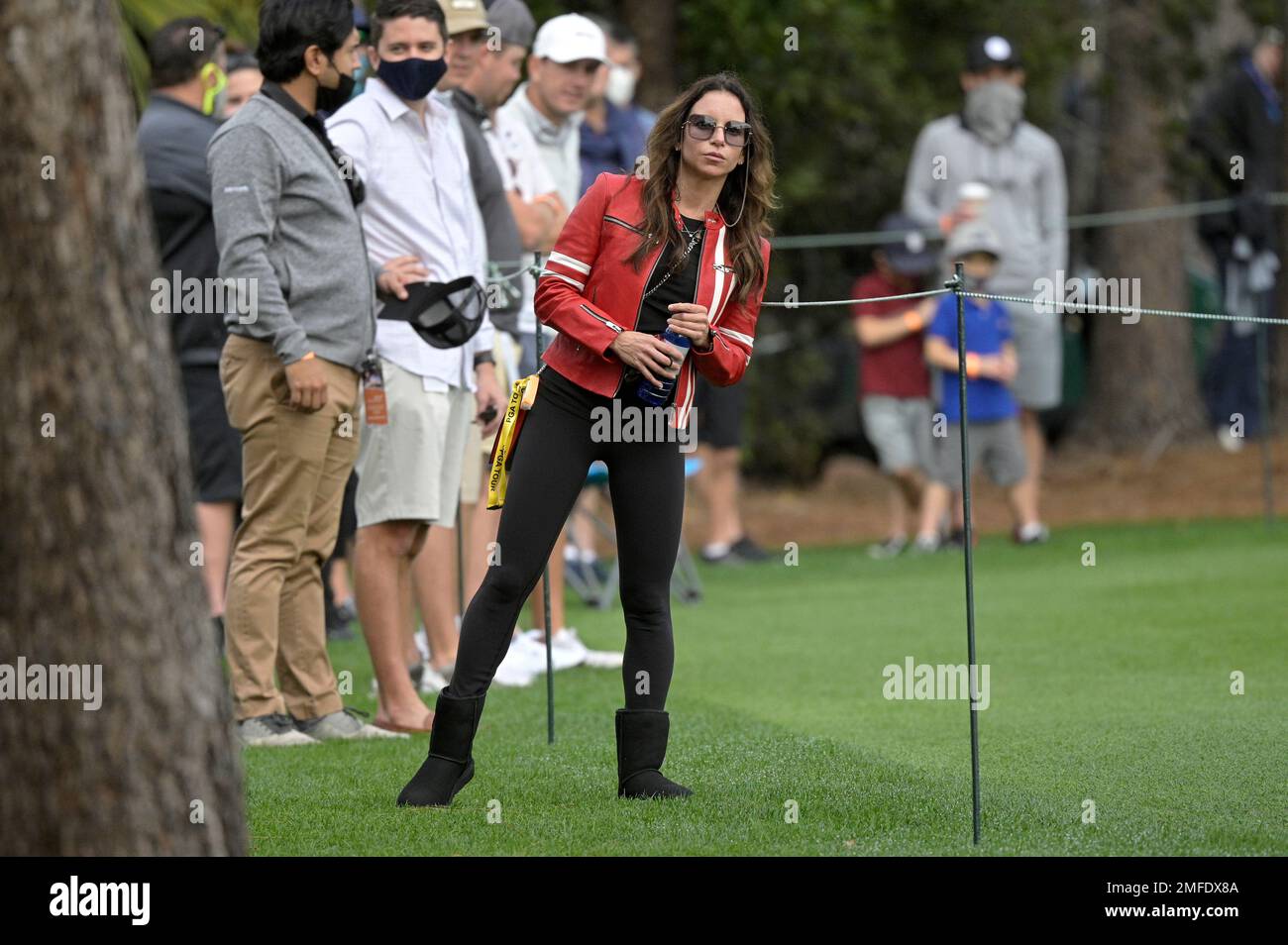 Erica Herman watches Tiger Woods and Charlie Woods on the third hole