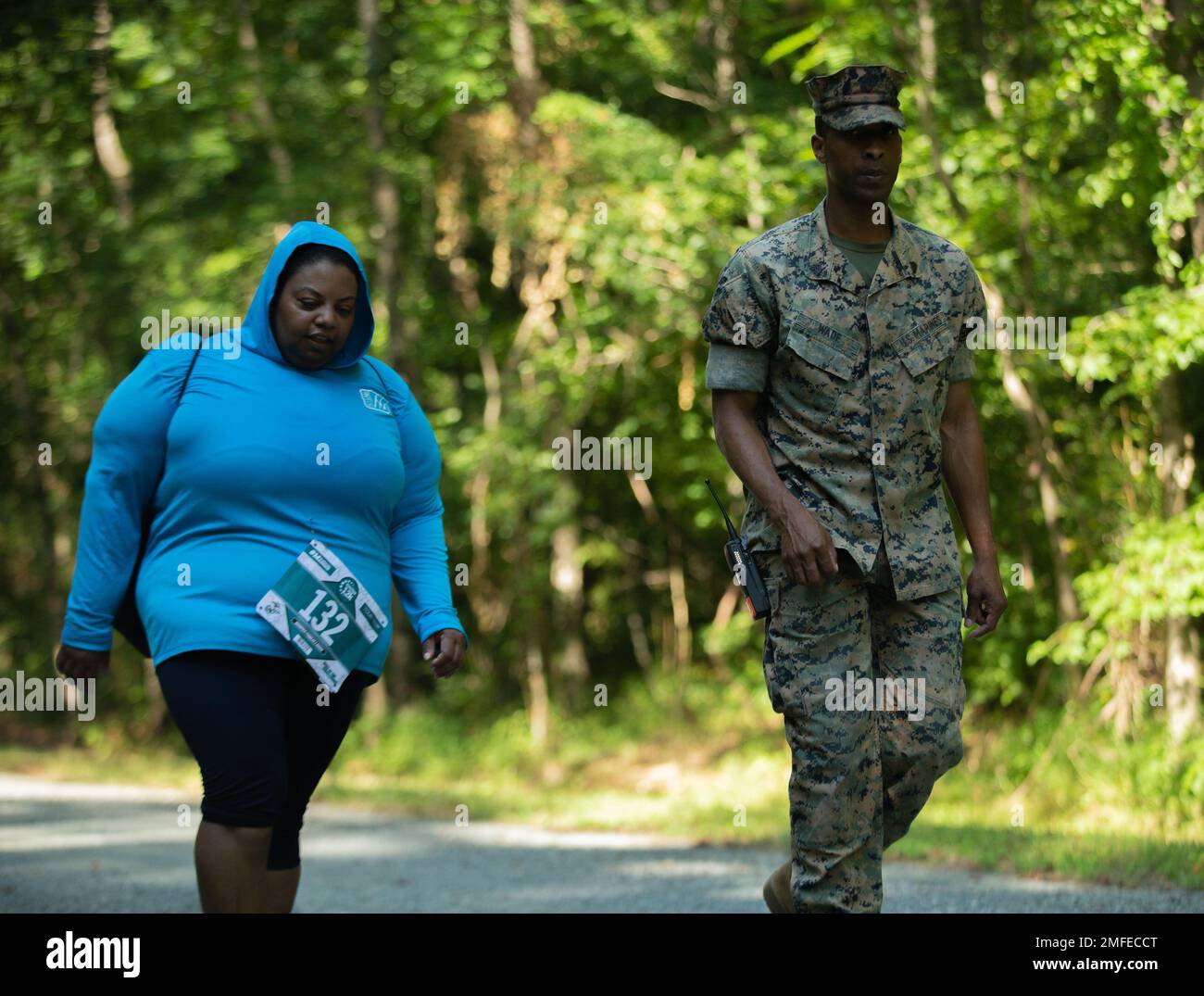 Sgt. Deshaza Wade, a Marine with Security Battalion, walks alongside Mrs. Carol Frazier-Guerin, a participant in the Quantico 12K at Marine Corps Base Quantico, Virginia, August 20, 2022. Sgt. Wade personally escorted Mrs. Frazier-Guerin the final 2.46 miles of the event offering motivation and words of encouragement every step of the way. Stock Photo