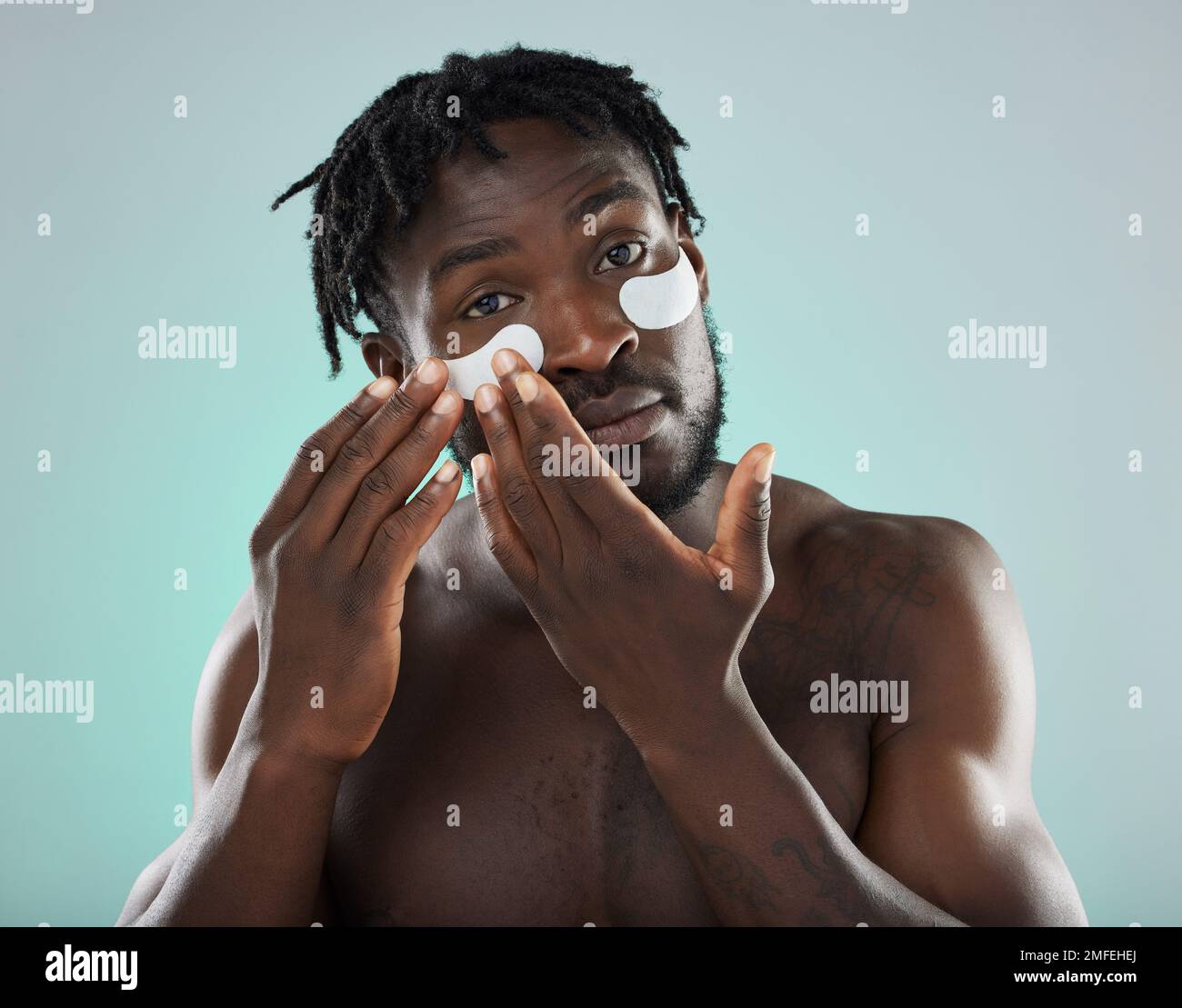 Eye patch, man and face portrait for skincare, beauty and dermatology in studio. Healthy black person on blue background for facial glow, clean skin Stock Photo