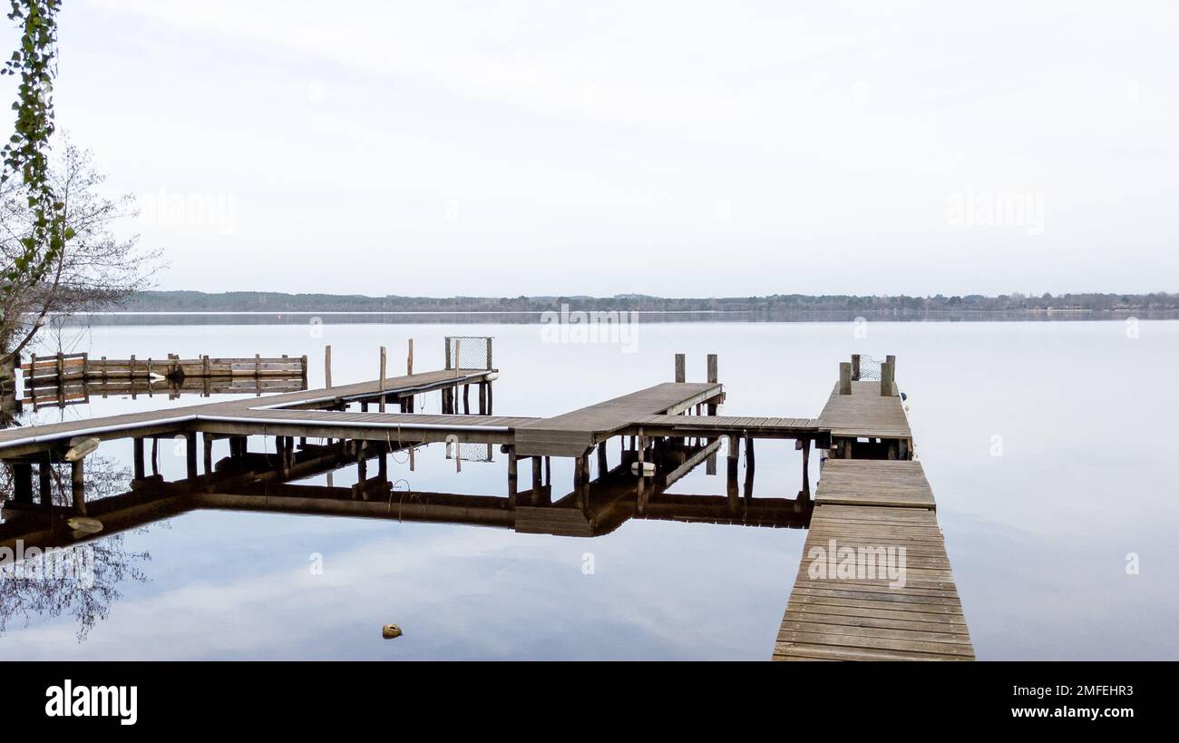 wood pontoon boat empty in french Leon lake water horizon calm water in southwest france Stock Photo