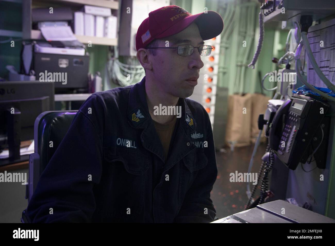 220821-N-XN177-1056 PHILIPPINE SEA (Aug. 21, 2022) – Damage Controlman 1st Class Corey O’Neill, from Driftwood, Pennsylvania, stands damage control console operator watch in central control station aboard amphibious assault carrier USS Tripoli (LHA 7), Aug. 21, 2022. Tripoli is operating in the U.S. 7th Fleet area of operations to enhance interoperability with allies and partners and serve as a ready response force to defend peace and maintain stability in the Indo-Pacific region. Stock Photo