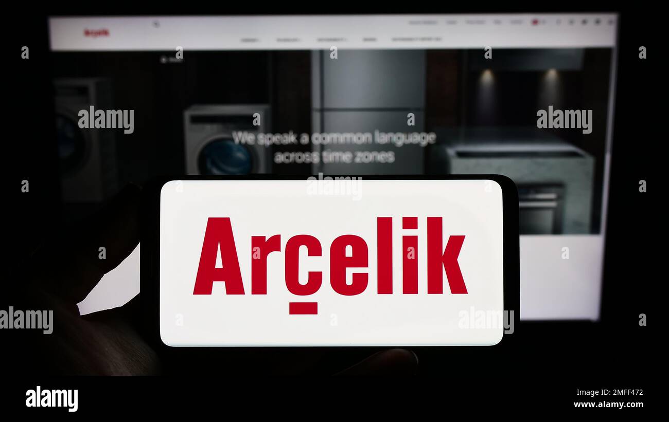 Person holding smartphone with logo of household appliances company Arcelik A.S. on screen in front of website. Focus on phone display. Stock Photo