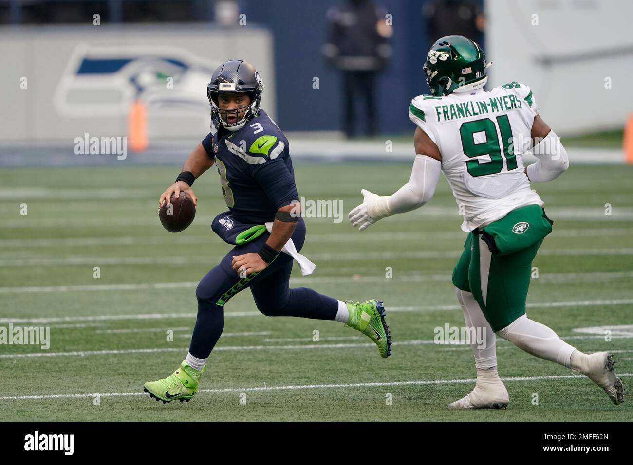Seattle Seahawks quarterback Russell Wilson, left, scrambles away from