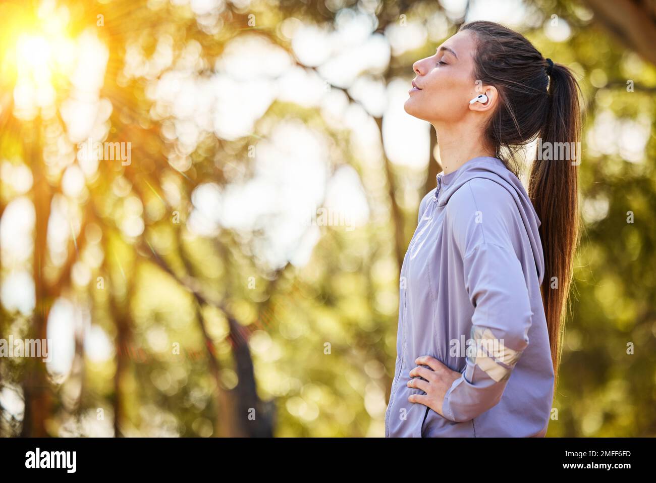 Calm, music and fitness person in nature for mental health, wellness and breathing, forest trees and fresh air. Mockup, sports and athlete woman Stock Photo
