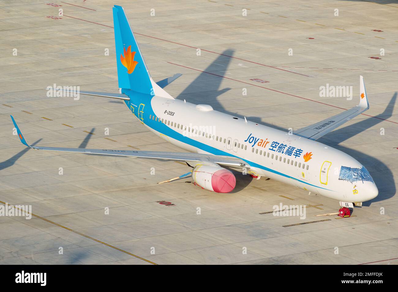A high-angle shot of the Joy Air Boeing 737-800 airplane parked at the ...