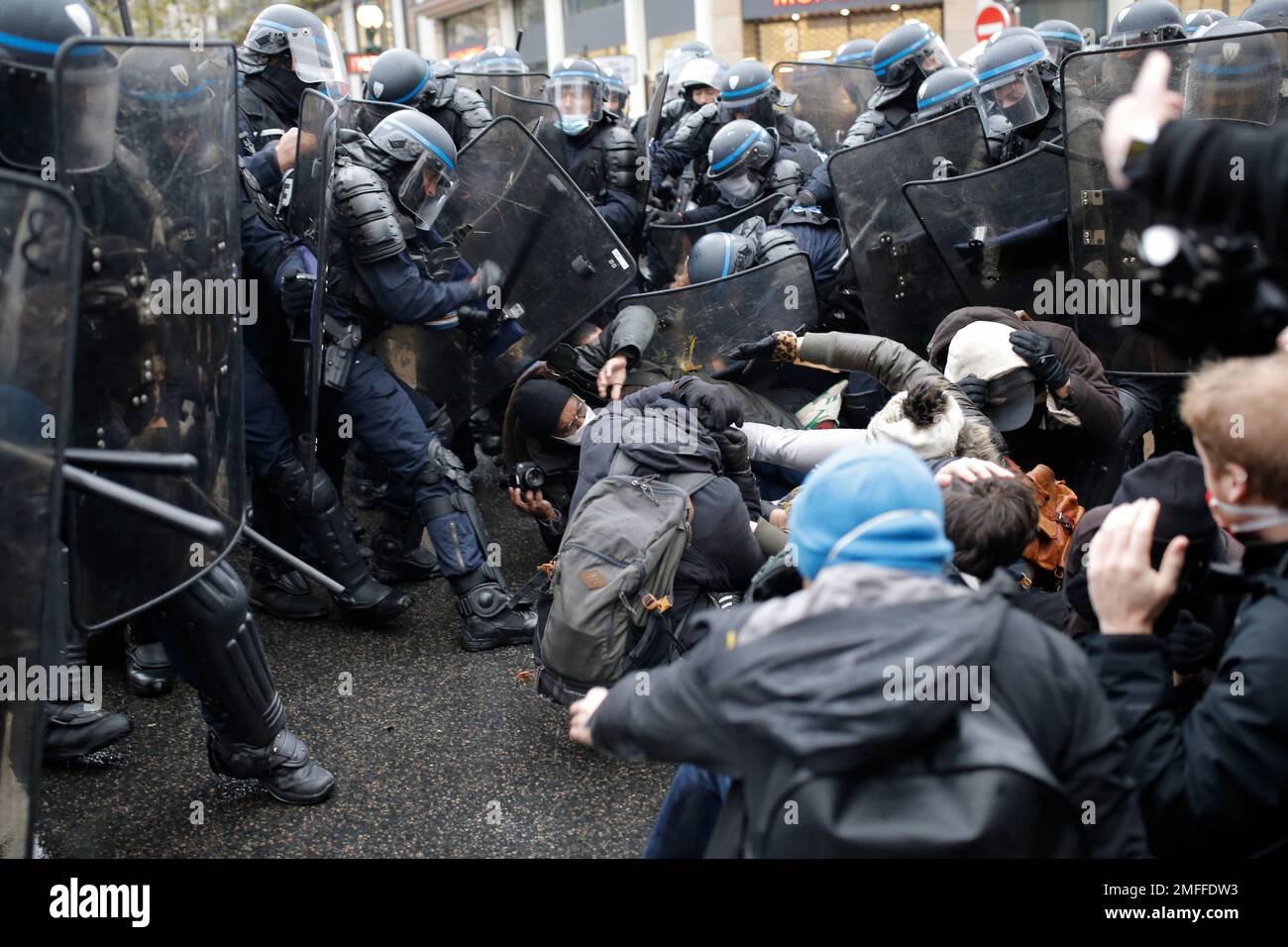 Riot police officers control a group of protesters during a protest ...