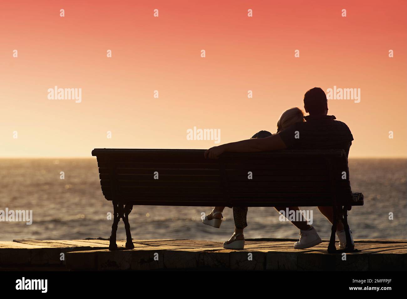 Silhouette romantic couple on a bench by the sea Stock Photo - Alamy