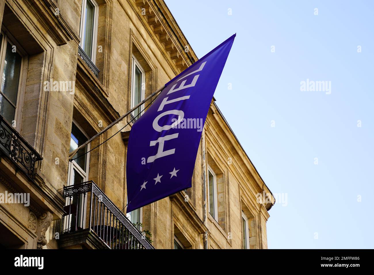 Hotel blue flag sign text three stars in wall building facade in french ...