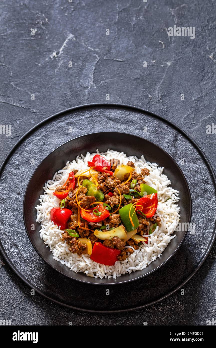 crispy ground beef with stirfried veggies and a stickysweet orange sauce topped on rice in