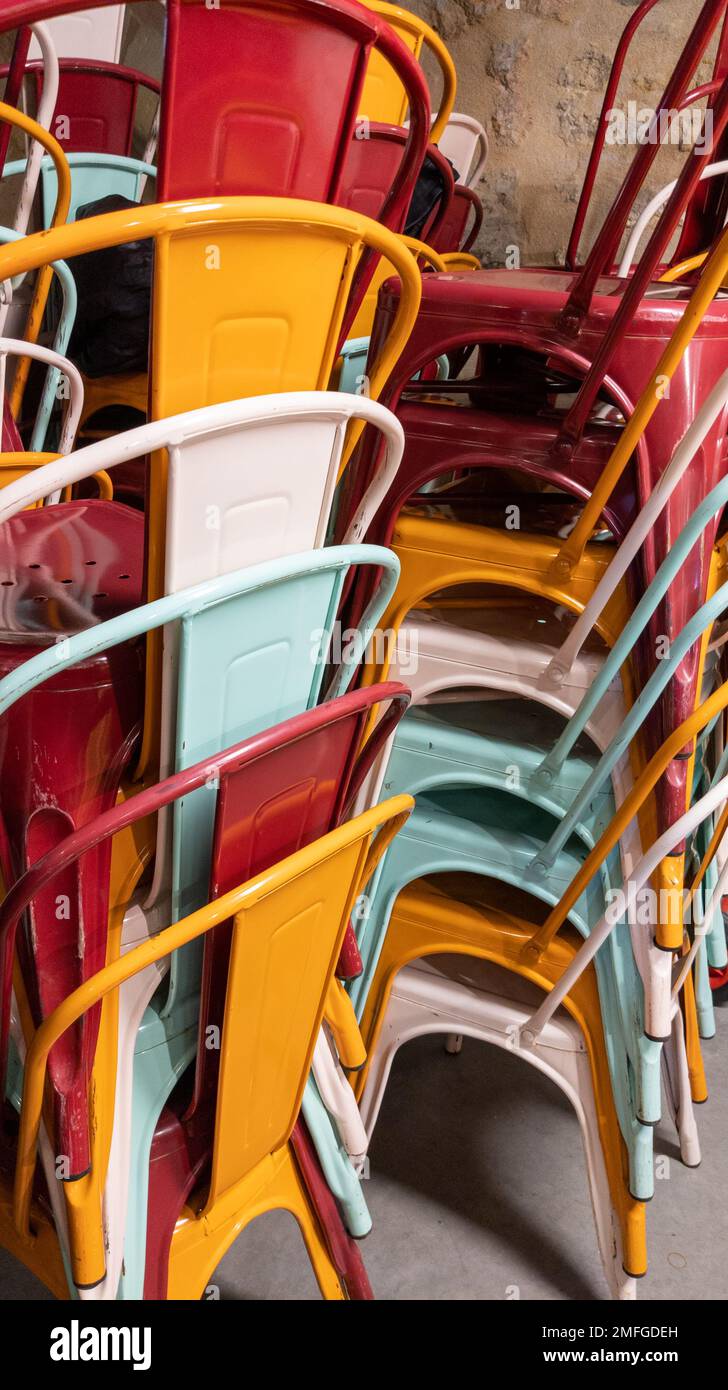 stack of multicolored chairs of Industrial Metal Chair on restaurant terrace Stock Photo