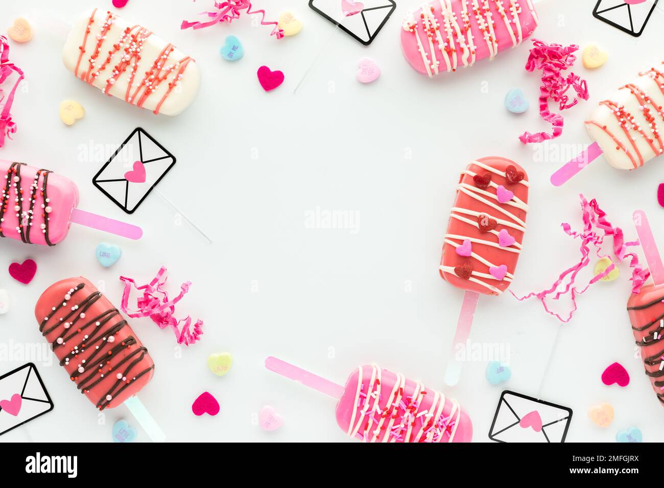A Valentine border background including cakesicles and decorations. Stock Photo