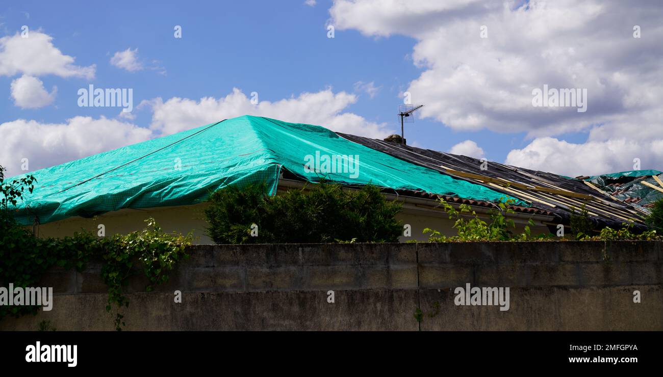 roof house temporary repair on badly storm damaged roof with a big
