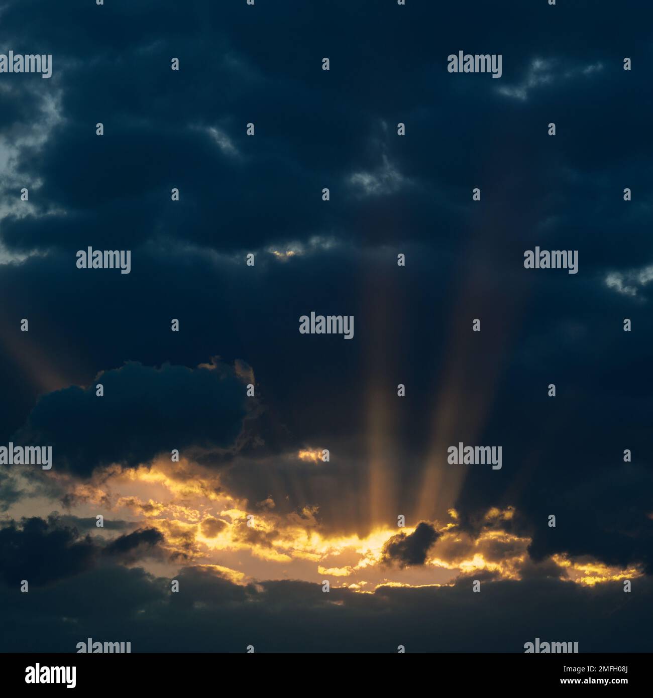 Dramatic sunset with dark clouds and glimpses of light, sun rays ...