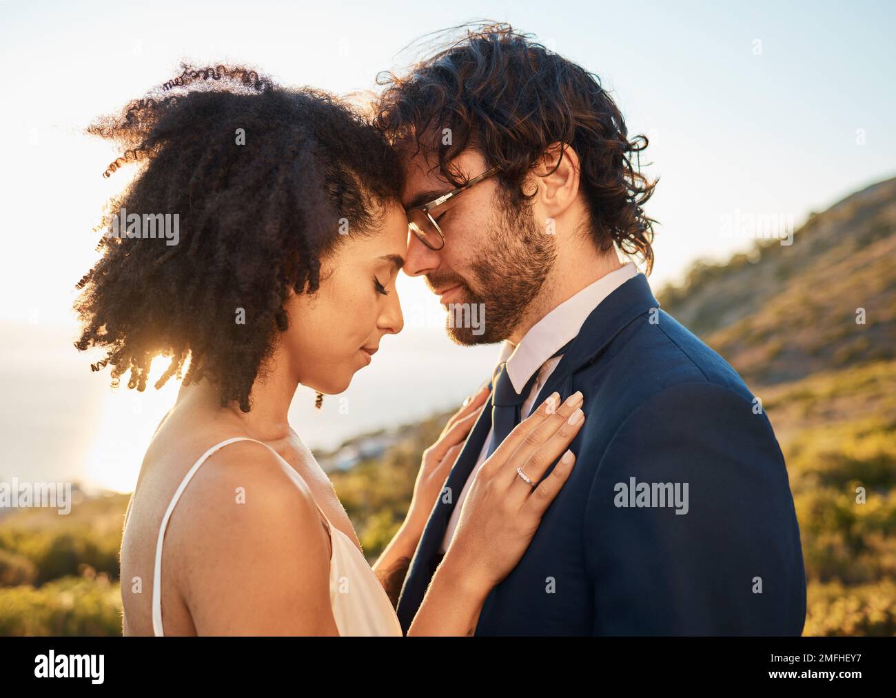 Marriage hug, interracial couple and nature with people outdoor for wedding and save the date. Close, love celebration and bride with man for Stock Photo