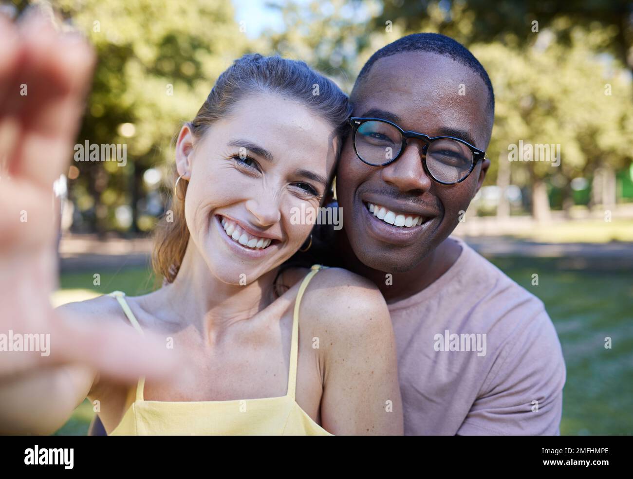 Love, smile and selfie with interracial couple at park for relax, social media and peace on romantic date. Support, happy and quality time with black Stock Photo