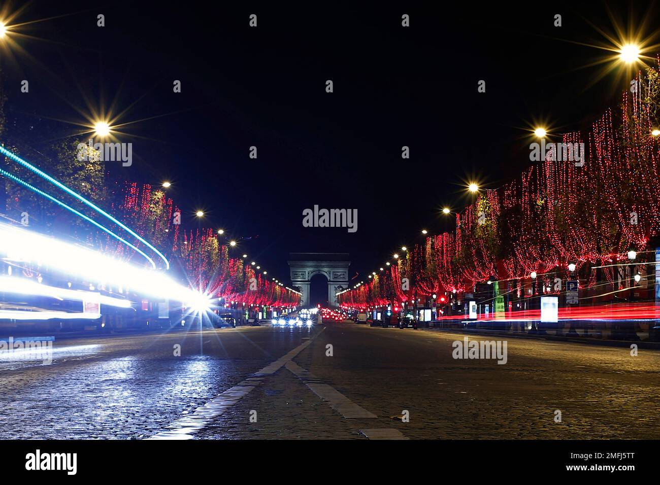 The Champs Elysees avenue with the Arc de Triomphe is illuminated as