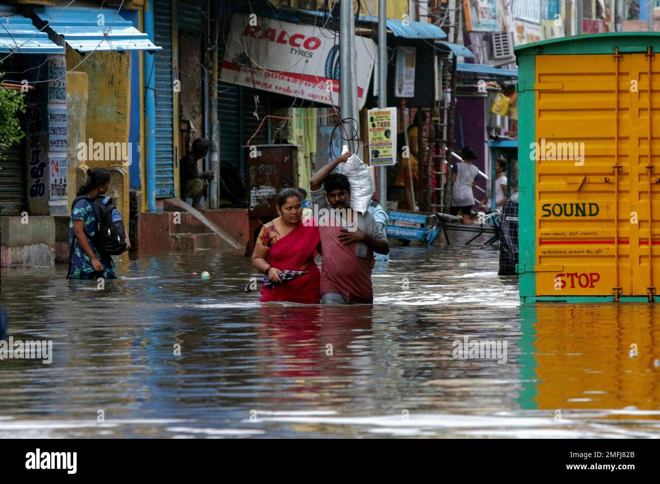 People wade through a flooded street in Chennai, India, Wednesday, Nov ...