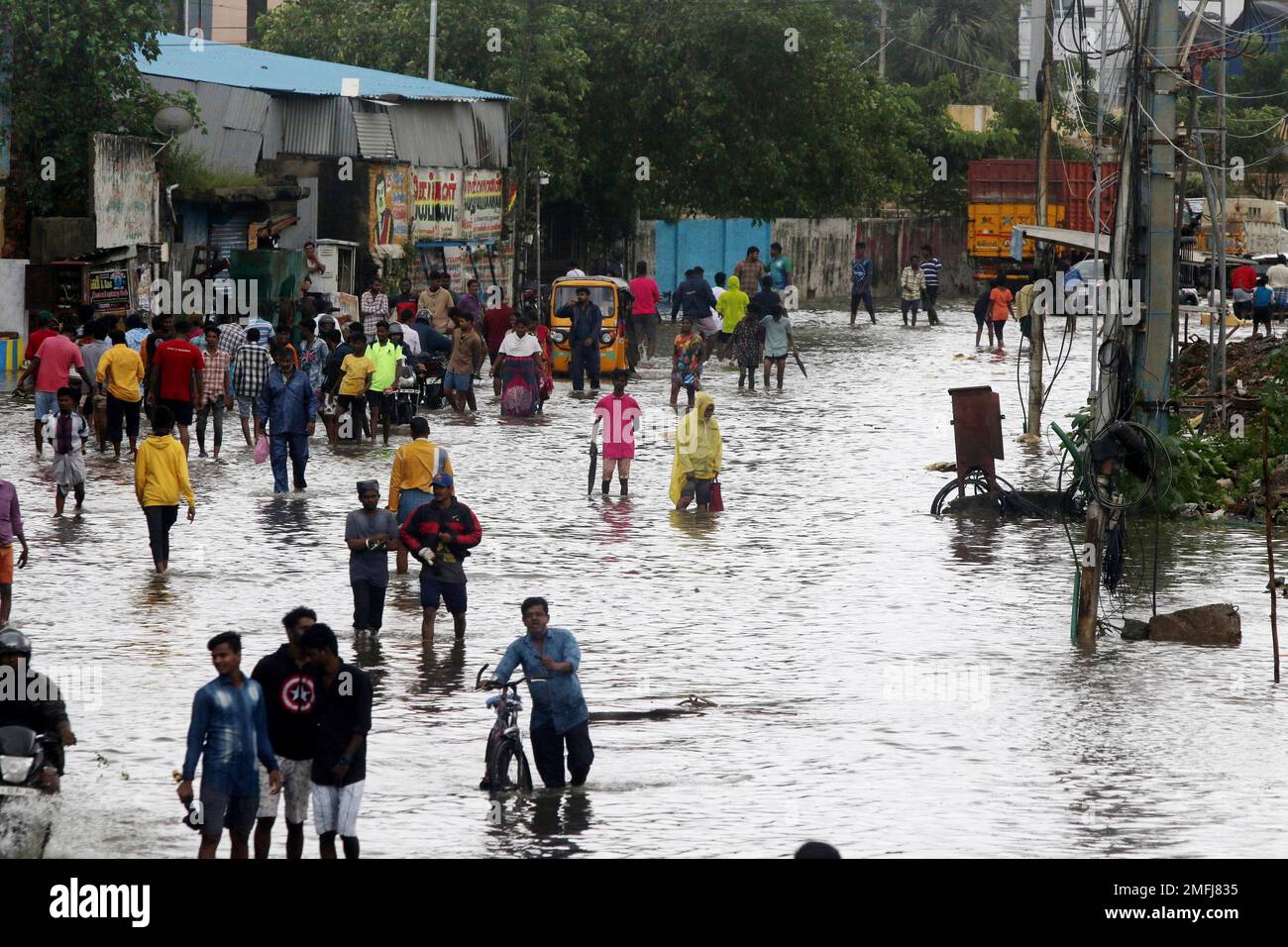 People wade through a flooded street in Chennai, India, Wednesday, Nov ...