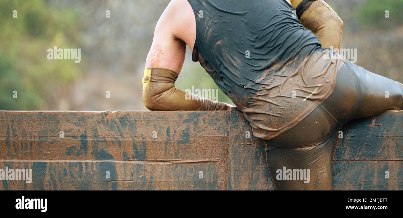 Mud race runners running over obstacles extreme sport Stock Photo