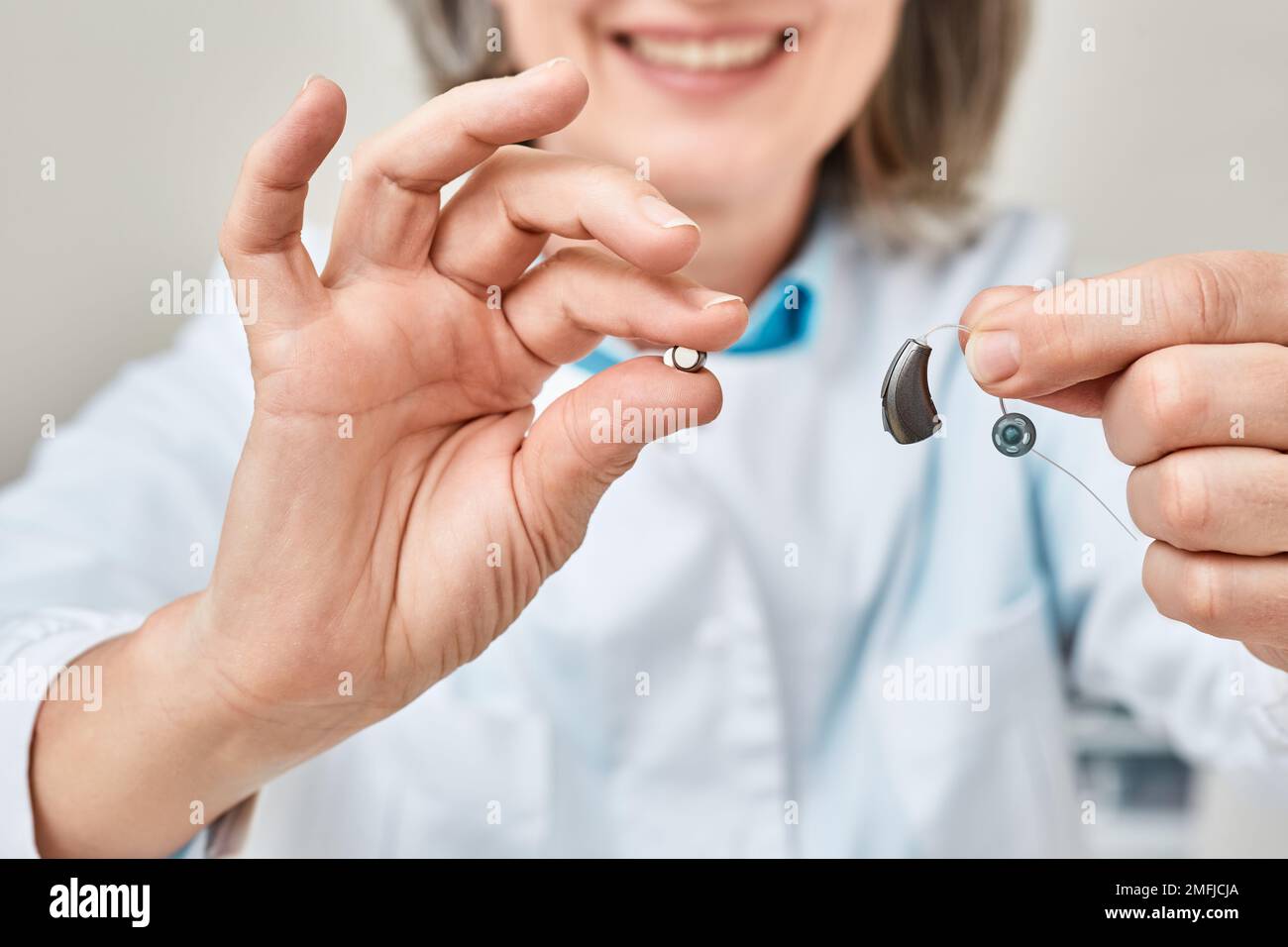 Hearing aid battery replacement. Positive audiologist showing hearing