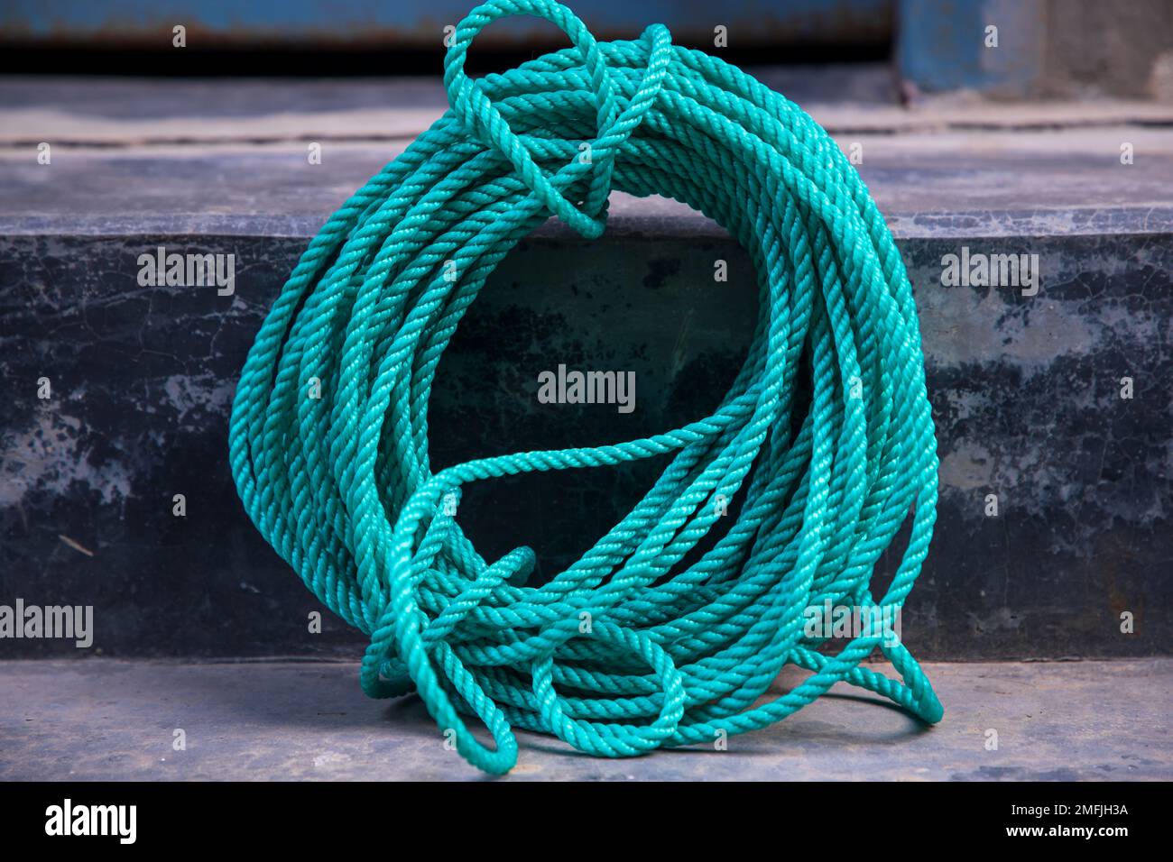 green rope on the cement floor background, vintage color tone. Stock Photo