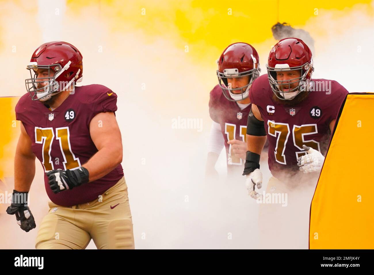 Members of the Washington Football Team taking the field, from l-r.,  offensive guard Wes Schweitzer (71), quarterback Alex Smith (11) and  offensive guard Brandon Scherff (75) before the start of the first