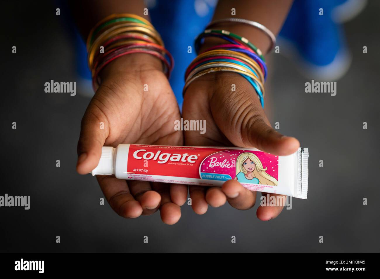 A 6-year-old girl poses while holding a tube of toothpaste in Malaysia ...