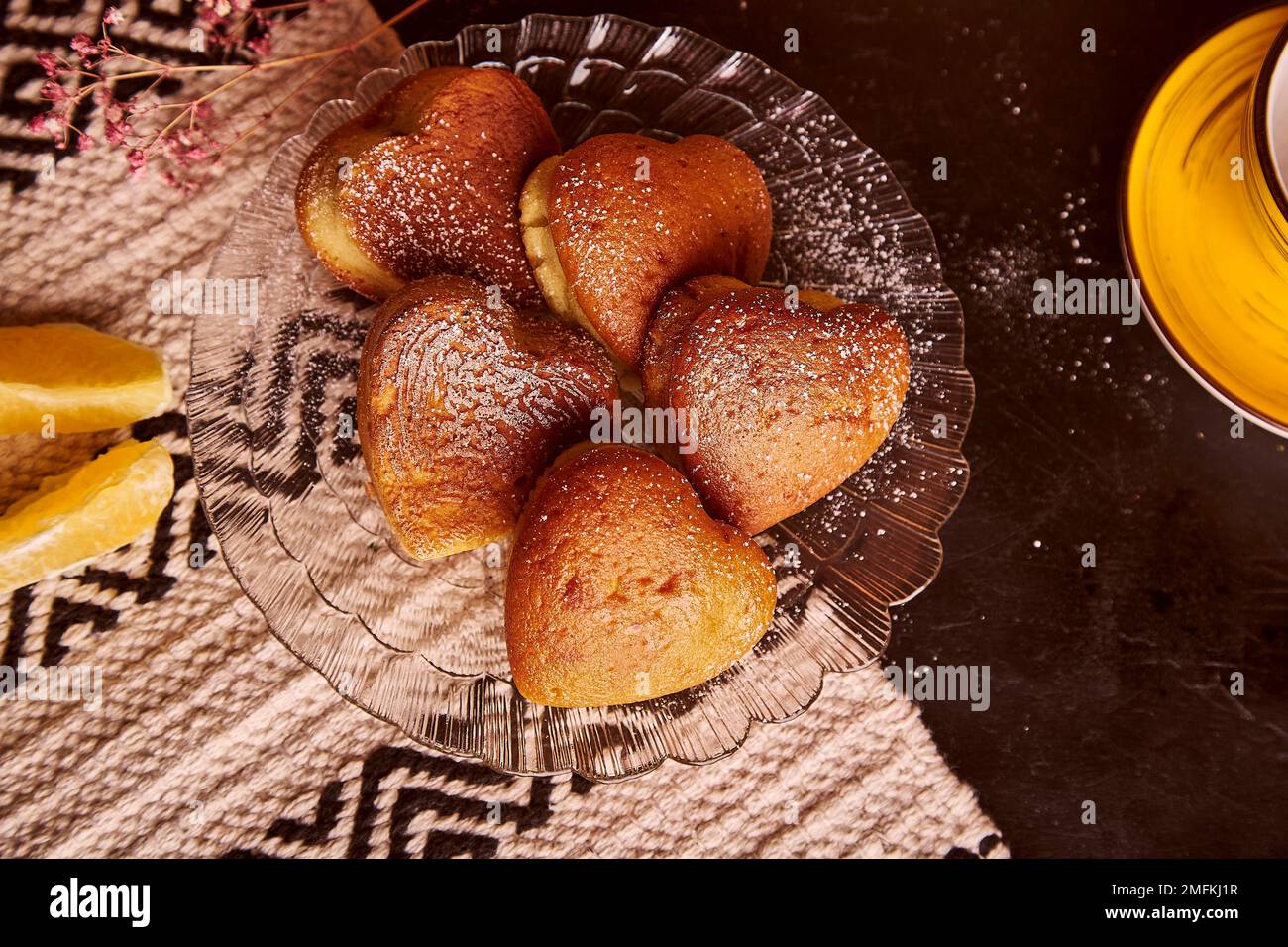 Homemade heart shaped cupcakes with orange taste for Valentines Day. Tea time aesthetics with fresh muffins. Stock Photo