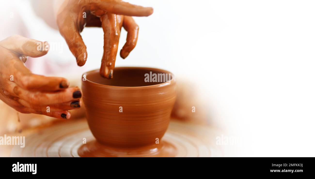 Cropped Image of hands working with pottery wheel, process of making cup or pot, banner, copy space. Stock Photo