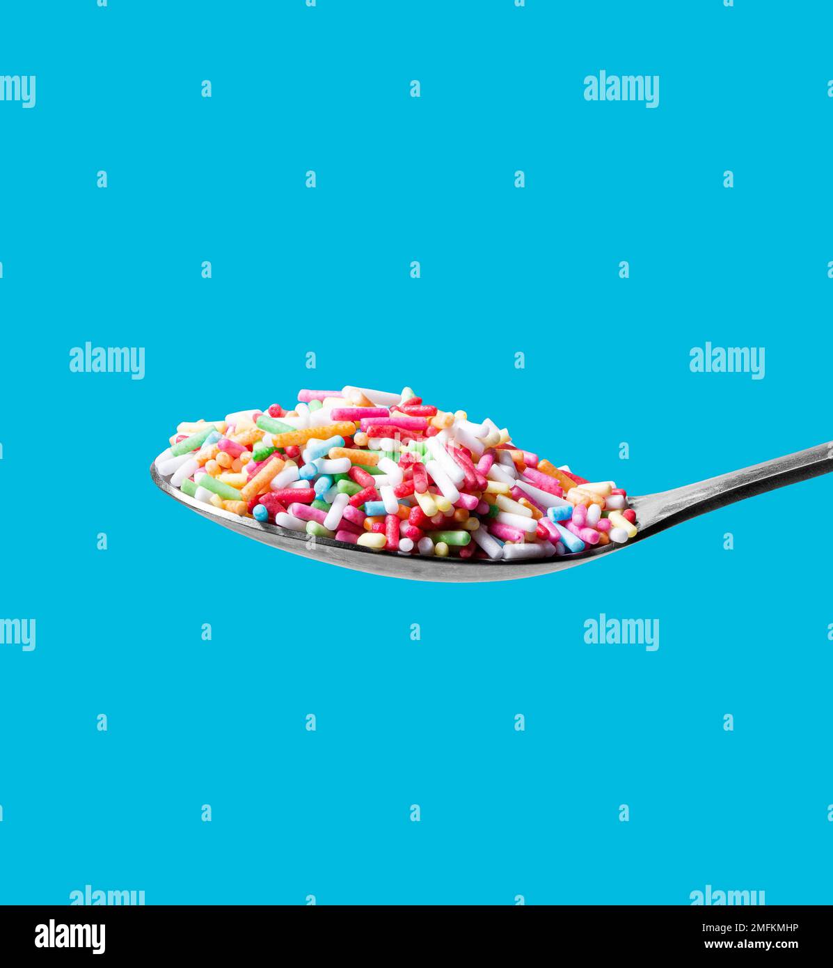 Photo of a spoon with confectionery sprinkles. Full depth of field