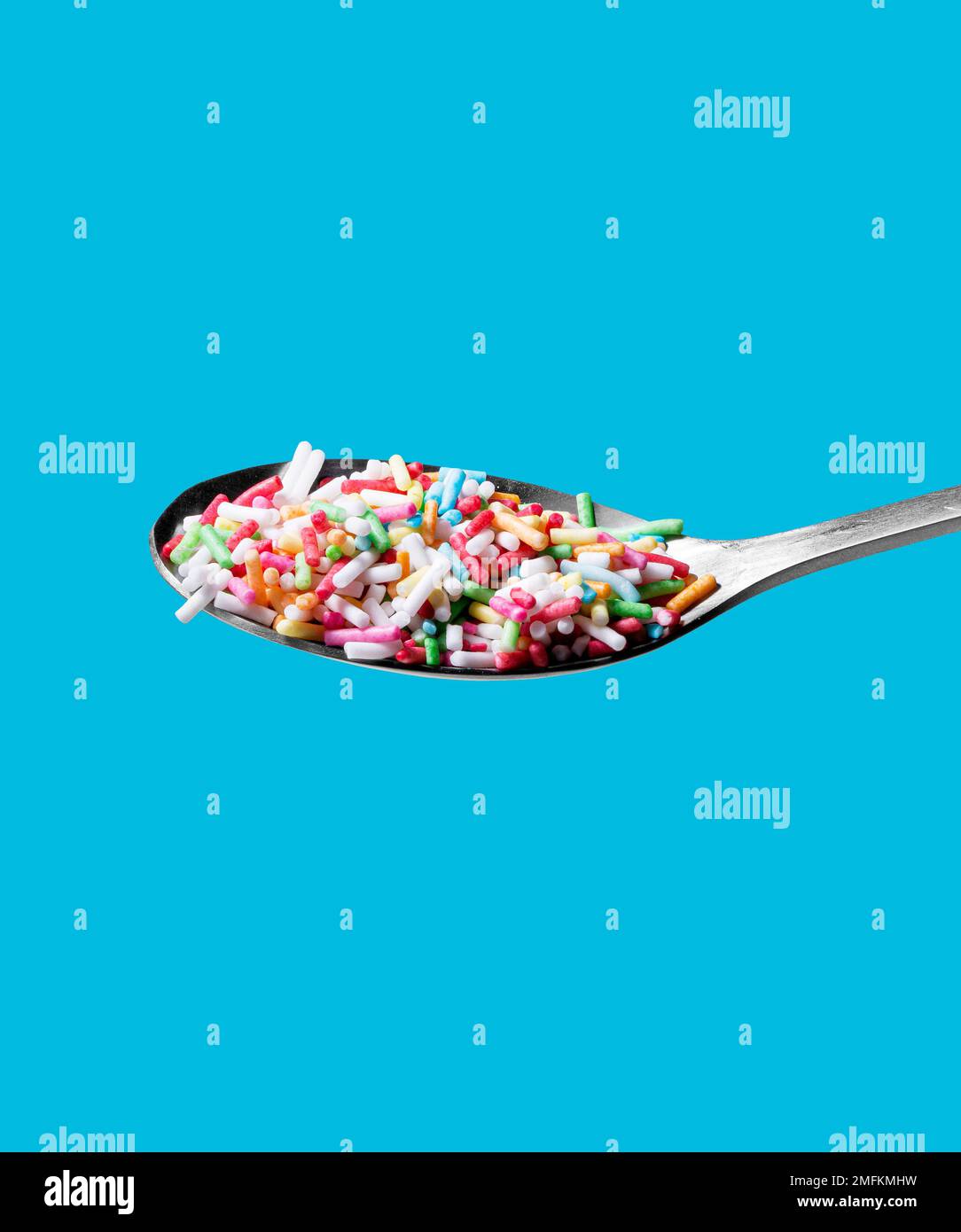 Photo of a spoon with confectionery sprinkles. Full depth of field